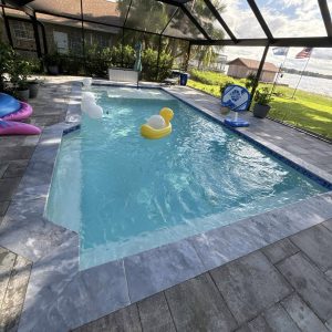 inground pool being cleaned with toys floating