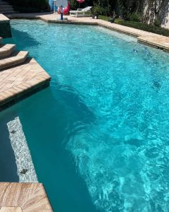 Inground pool with a custom stepped patio deck
